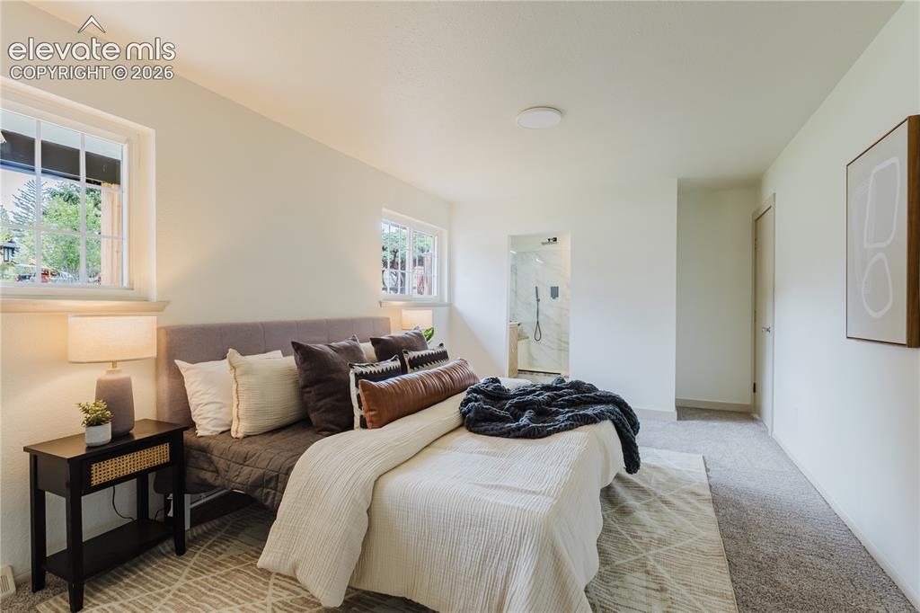 Image 15 of 47: Bedroom featuring light-colored walls and two windows with white trim