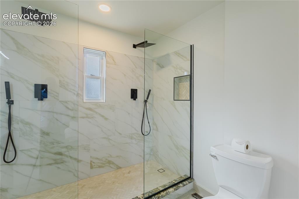 Image 18 of 47: Spacious walk-in shower with floor-to-ceiling glass enclosure, large format