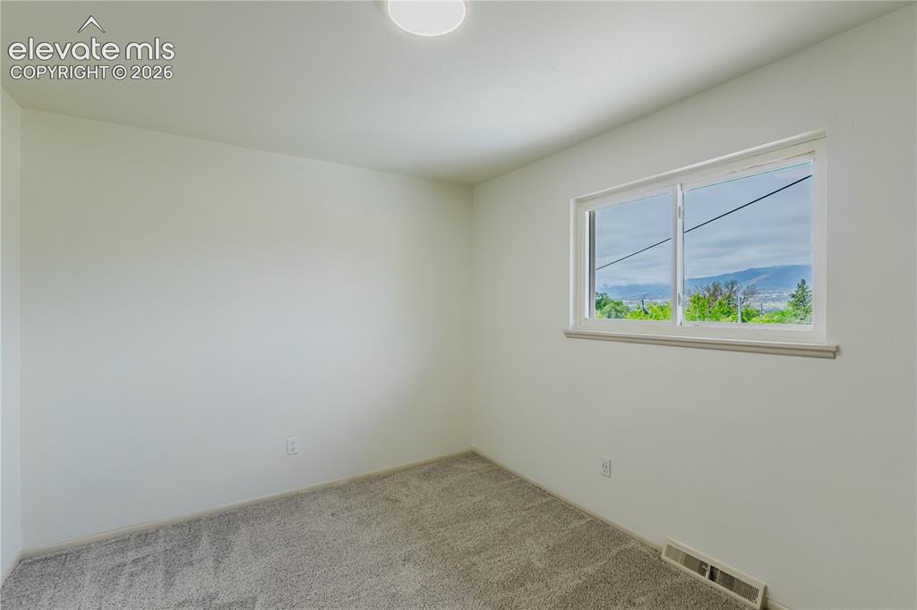 Image 19 of 47: 2nd Bedroom - Light-filled room featuring a broad window, white painted wa
