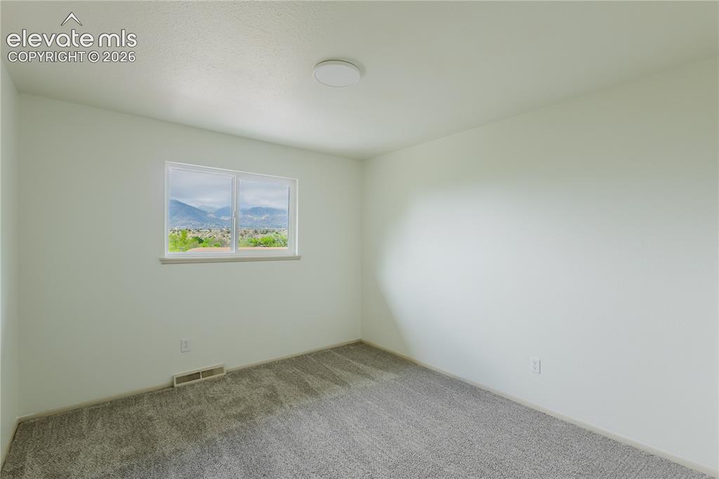 Image 22 of 47: 3rd bedroom - Bright interior space featuring a window with a distant mount