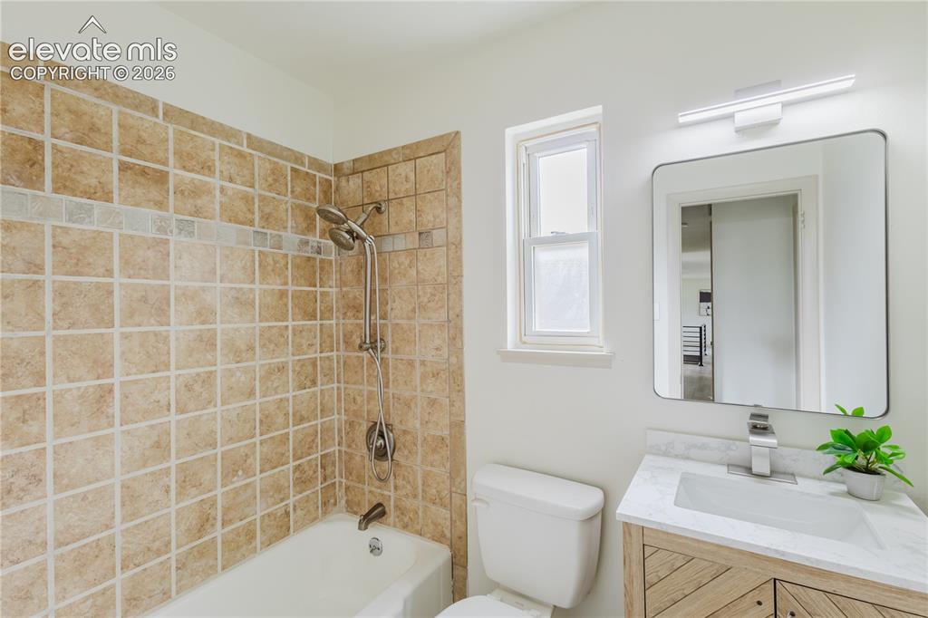 Image 24 of 47: Bathroom featuring a tiled shower and bathtub combination with a multi-func