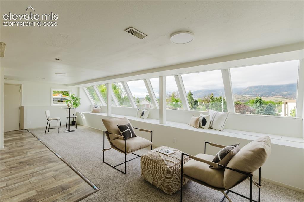 Image 26 of 47: Bright room featuring panoramic windows, a built-in window bench, wood-fini