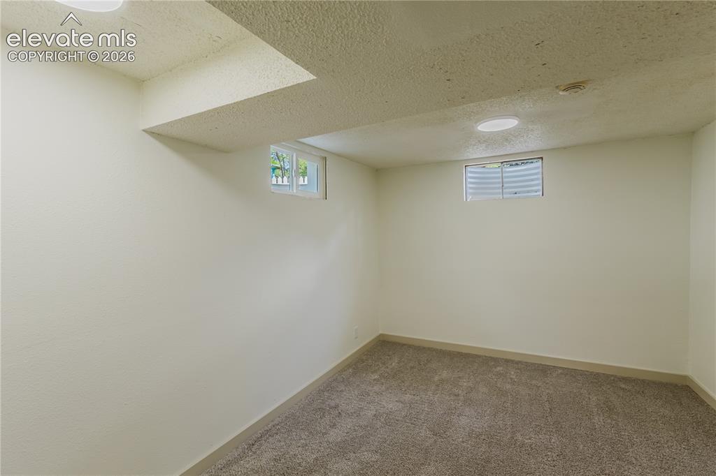 Image 29 of 47: 4th bedroom - Carpeted room featuring two egress windows with horizontal bl