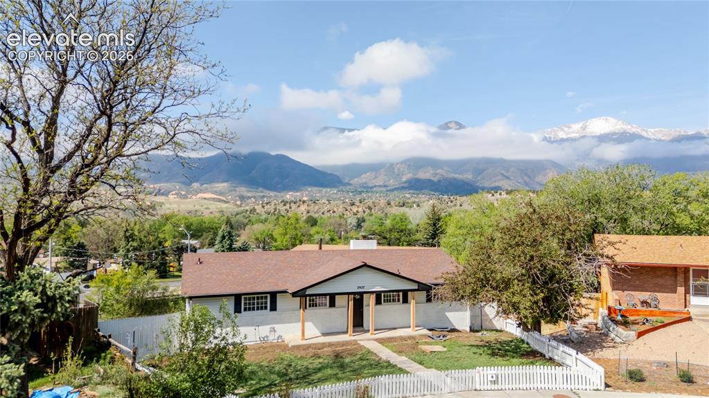 Image 3 of 47: Ranch-style residence featuring a white picket fence, a brown shingle roof,