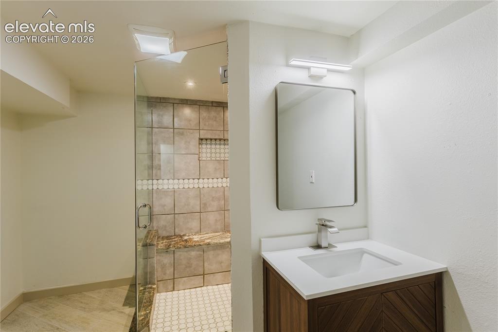 Image 32 of 47: Contemporary bathroom featuring a walk-in shower with glass enclosure, mosa