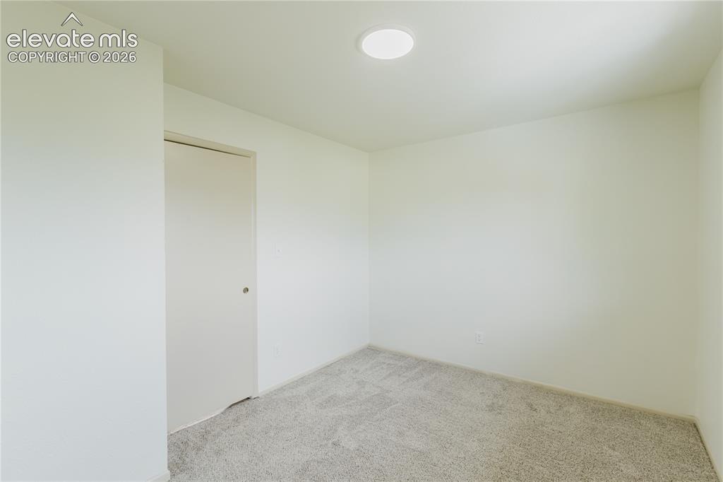 Image 39 of 47: Neutral tone wall paint, light-colored carpet, and a flush-mount ceiling li