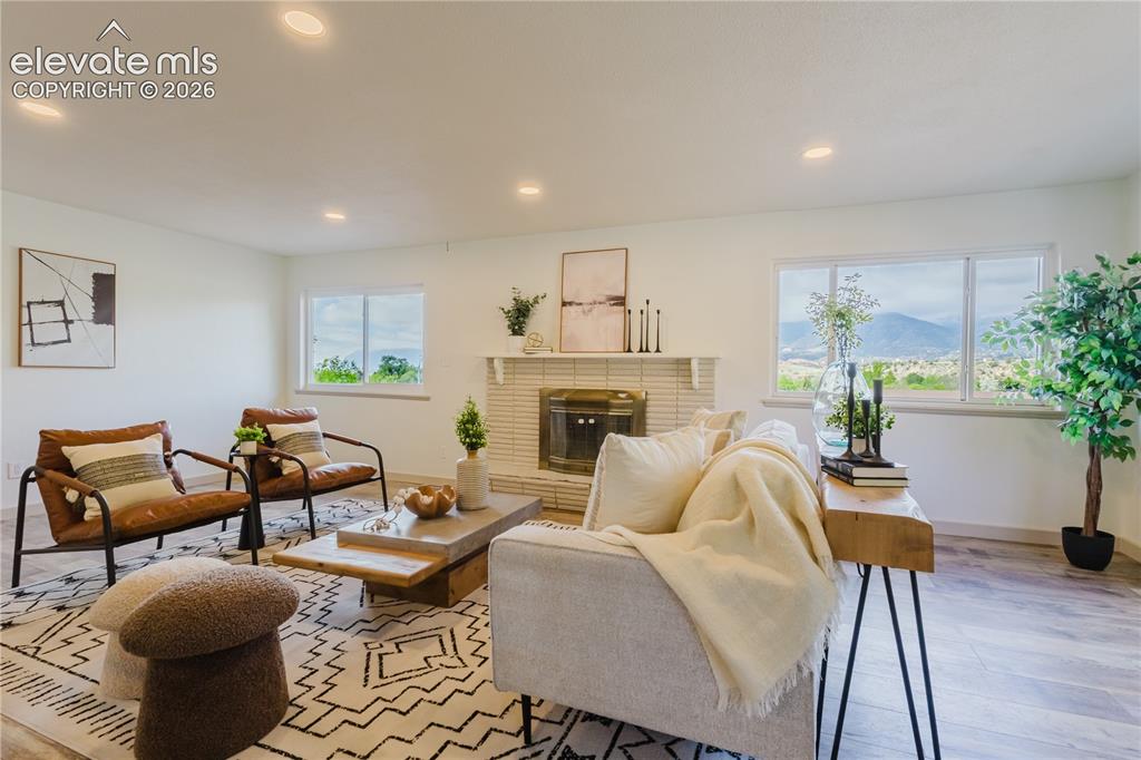 Image 4 of 47: Spacious living area featuring recessed lighting, a tiled fireplace with ma