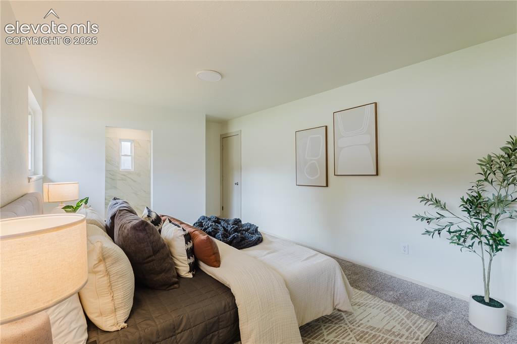 Image 43 of 47: Carpeted bedroom with white walls, recessed ceiling lighting, and a doorway