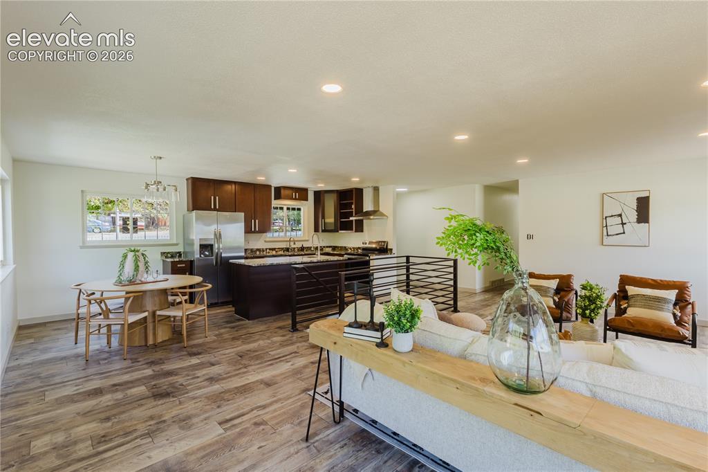 Image 6 of 47: Open-concept living space featuring wood-finish flooring, recessed lighting