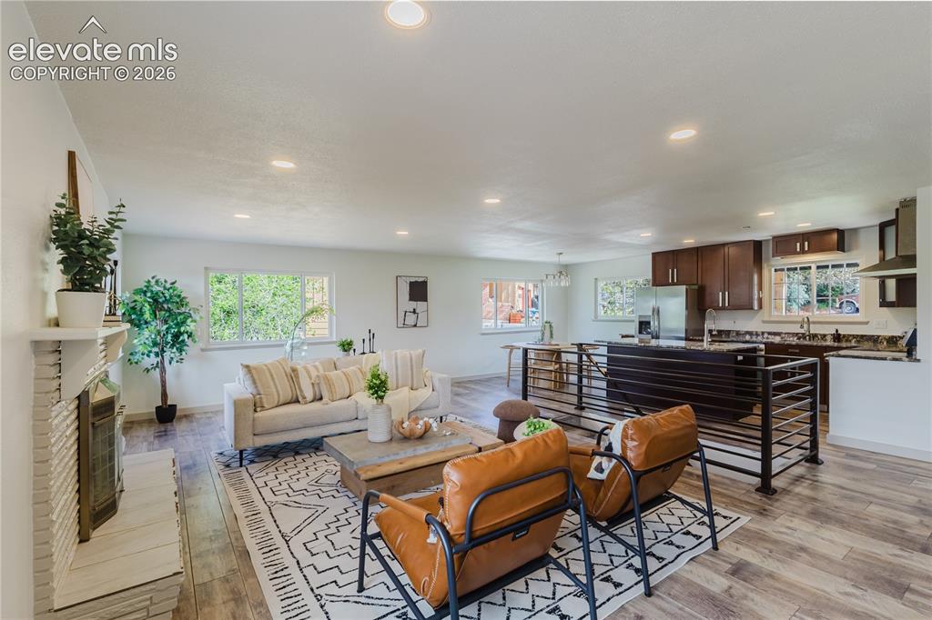 Image 7 of 47: Open-concept living space featuring wood-finish flooring, recessed lighting