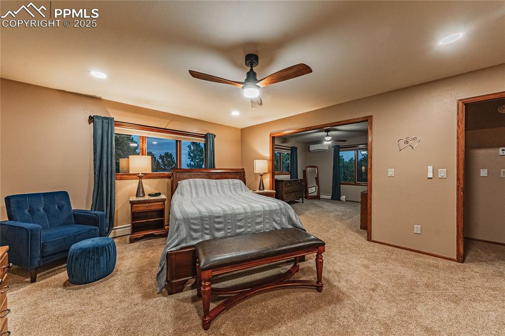 Image 13 of 39: Bedroom with carpet floors, baseboards, a wall unit AC, and recessed lighti