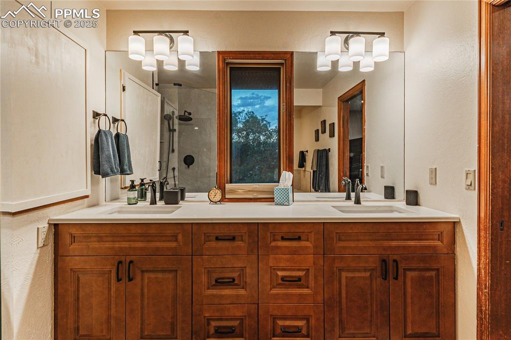Image 19 of 39: Bathroom with a stall shower, double vanity, and a textured wall