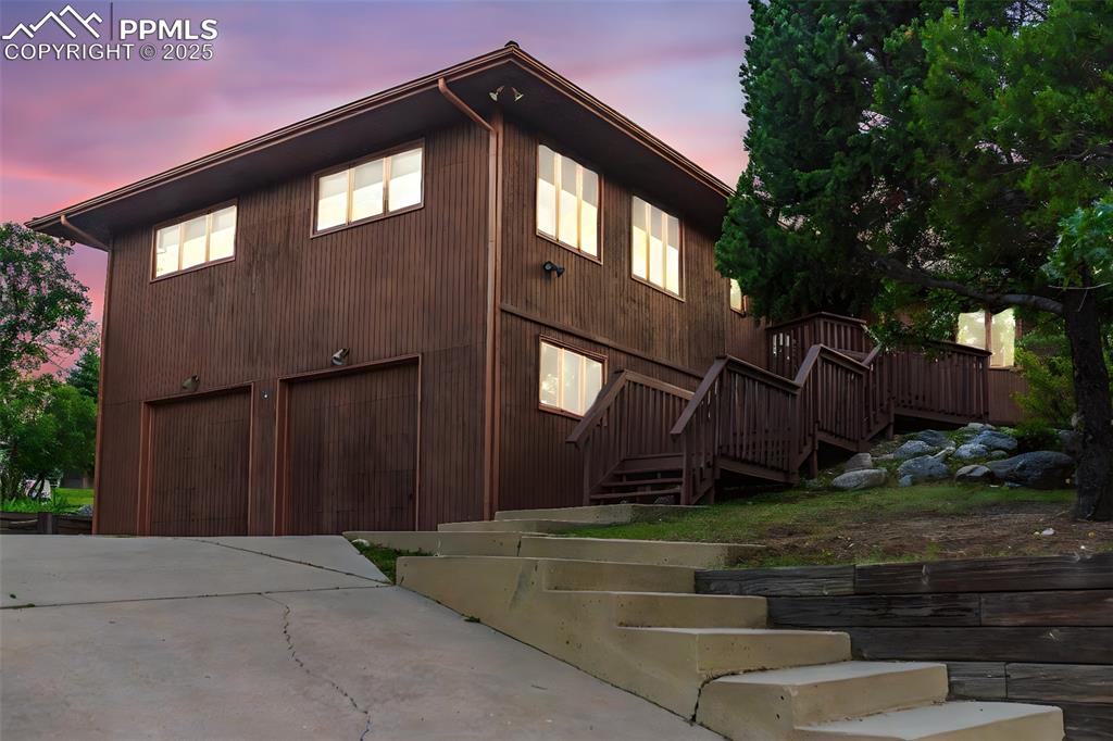 Image 2 of 39: View of front of home with driveway, an attached garage, stairway, and a wo