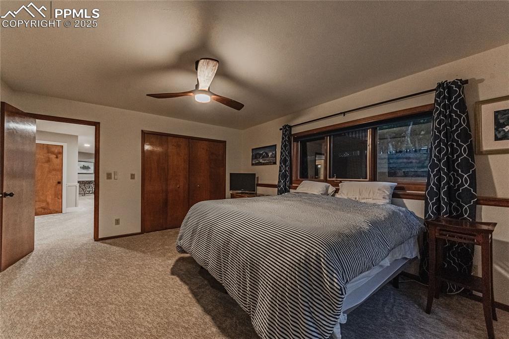 Image 28 of 39: Carpeted bedroom with a closet and ceiling fan