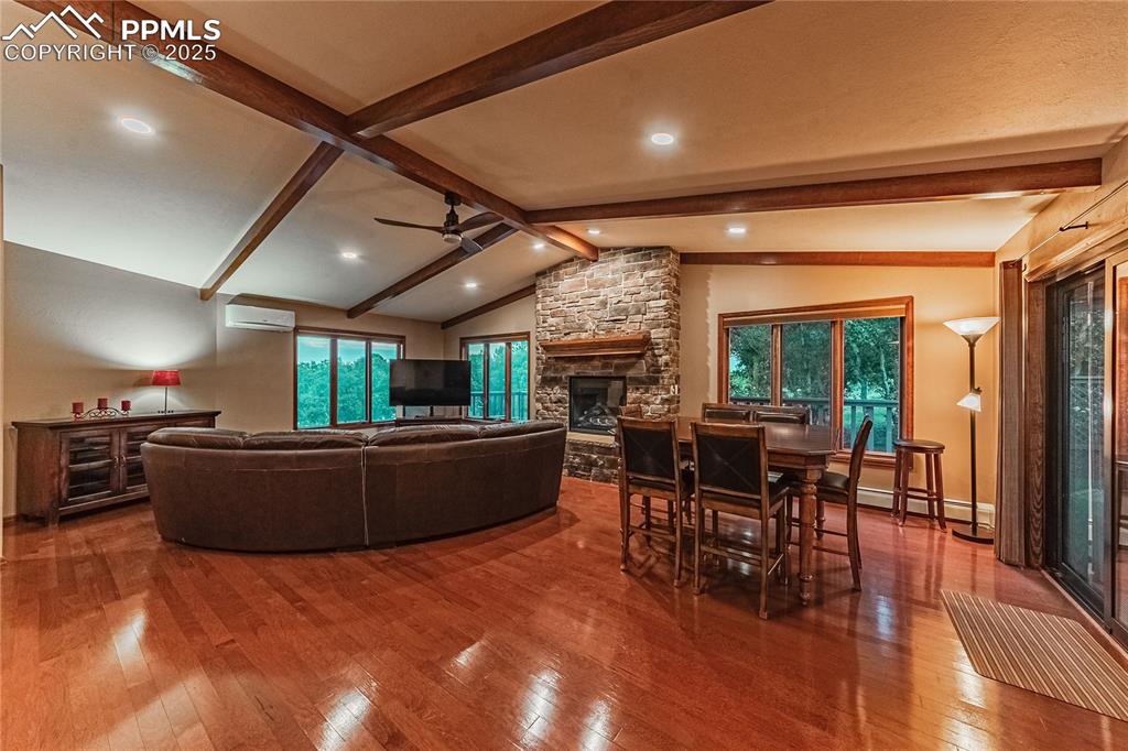 Image 5 of 39: Living area featuring hardwood / wood-style flooring, a ceiling fan, a ston