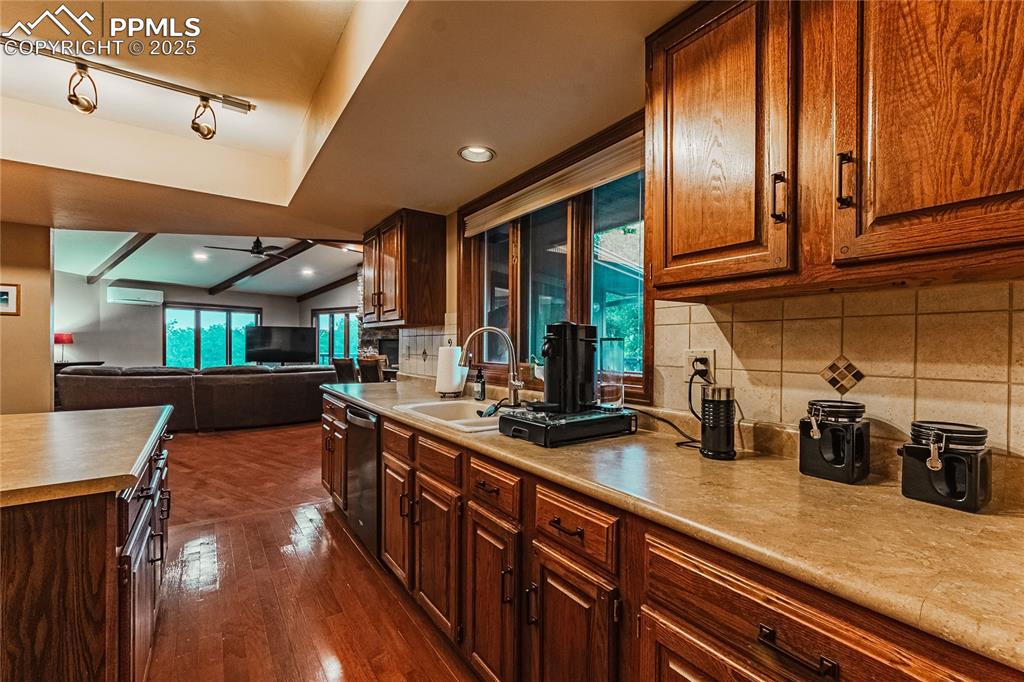 Image 7 of 39: Kitchen featuring a sink, dishwasher, ceiling fan, dark wood-style floors,