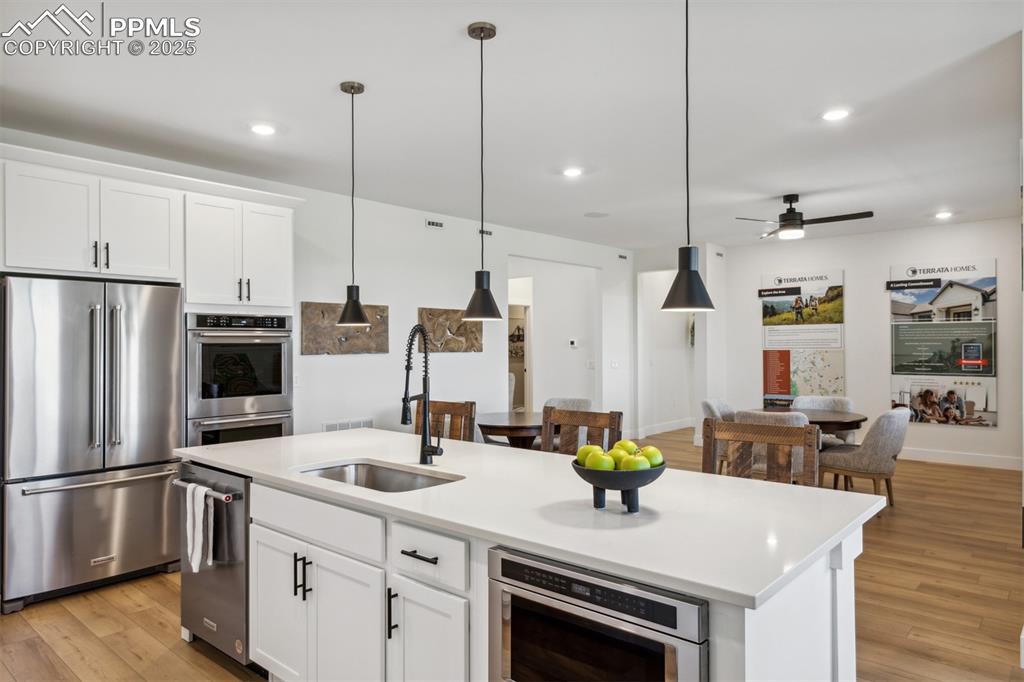 Image 7 of 23: Kitchen with light wood-type flooring, light countertops, a center island w
