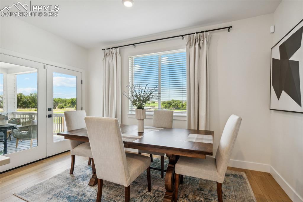 Image 9 of 23: Dining room with french doors, wood-type flooring, and baseboards