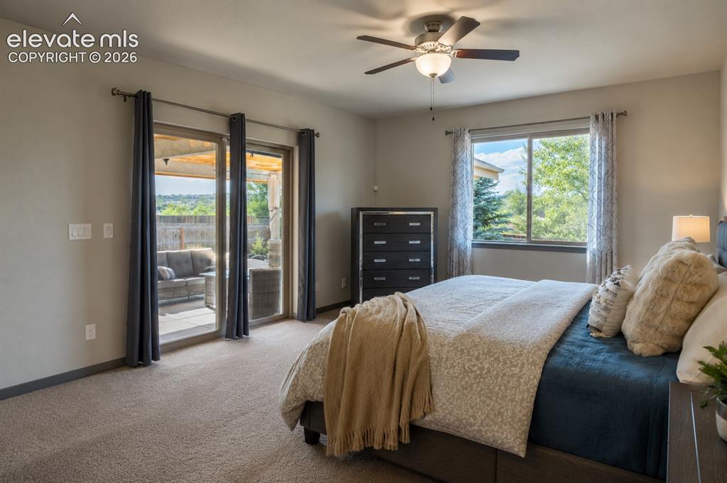 Image 10 of 31: Main-level Primary Bedroom with door to the covered patio