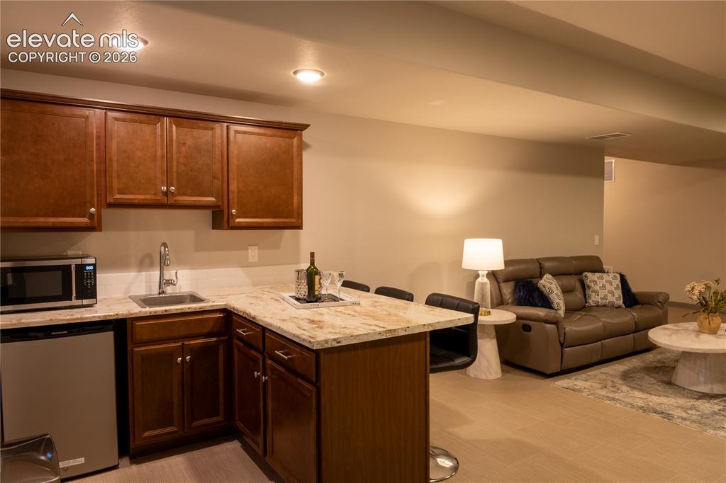 Image 16 of 31: Wet bar with fridge in Family Room