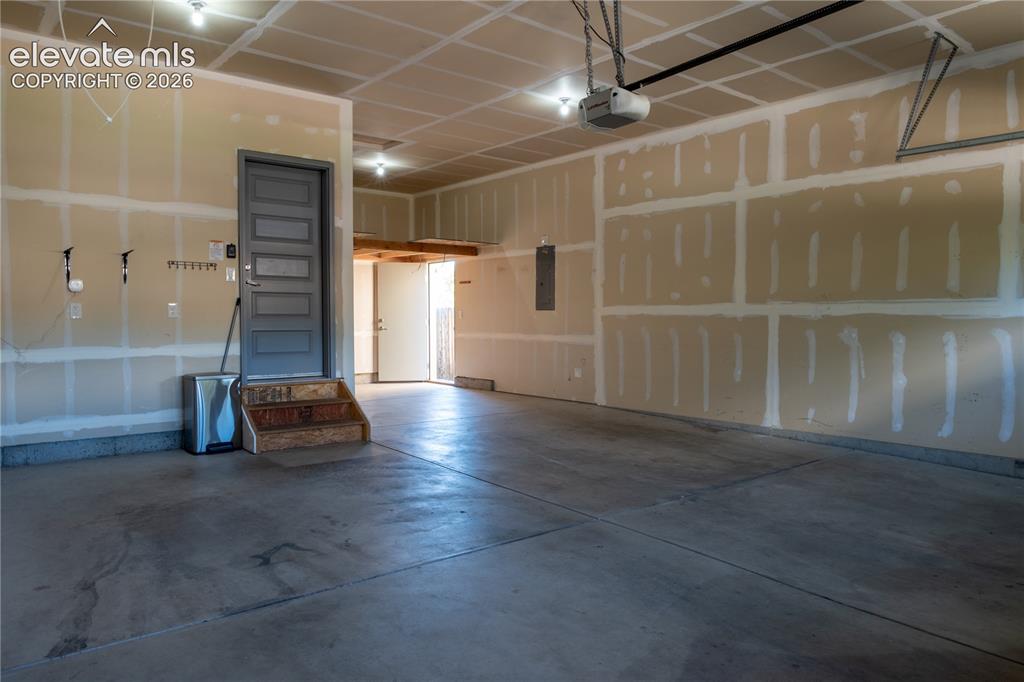 Image 29 of 31: Three-car garage with service door