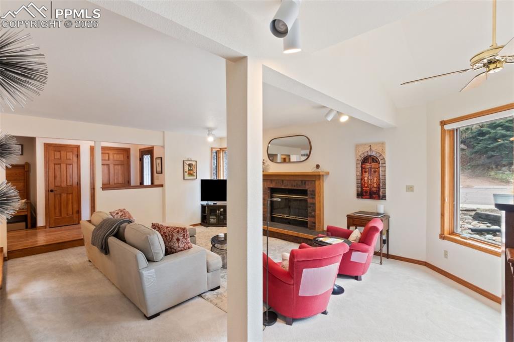 Image 14 of 47: Living room featuring a wood burning fireplace and large windows for a lot 