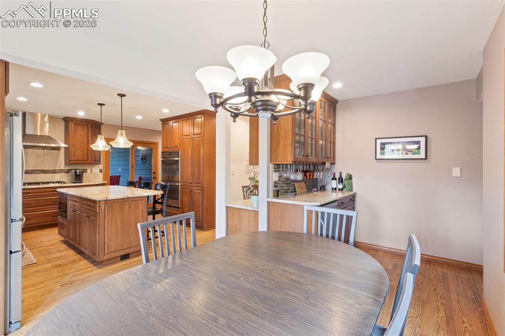 Image 19 of 47: Open-concept kitchen and second dining area featuring hardwood flooring and