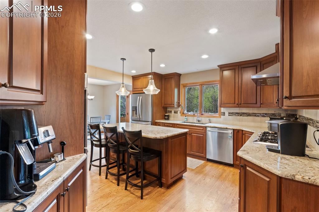 Image 21 of 47: Gourmet kitchen featuring a large island with bar seating, granite countert
