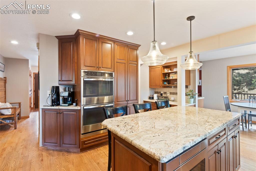Image 22 of 47: Gourmet kitchen featuring a large island with bar seating, granite countert