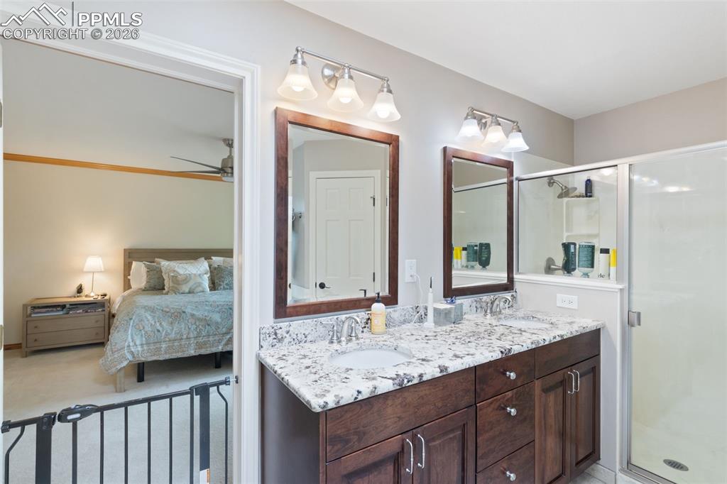 Image 30 of 47: Bathroom featuring a double vanity with granite countertops, integrated sin