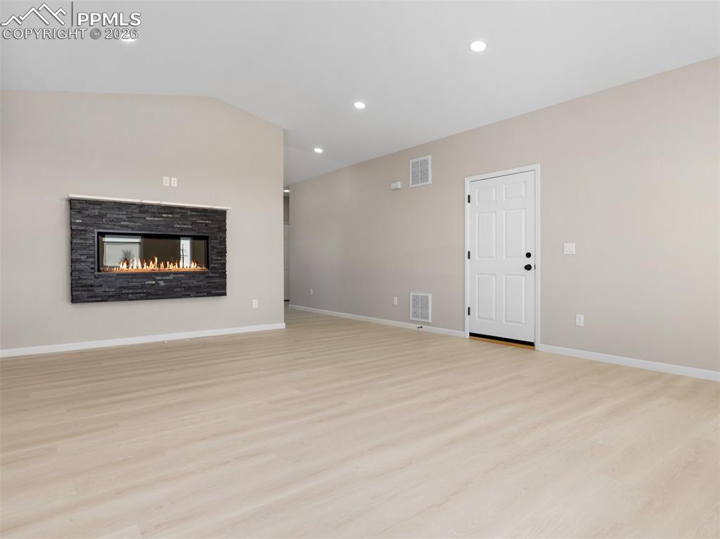 Image 4 of 26: Beautiful electric fireplace with stone accents giving the living room an e