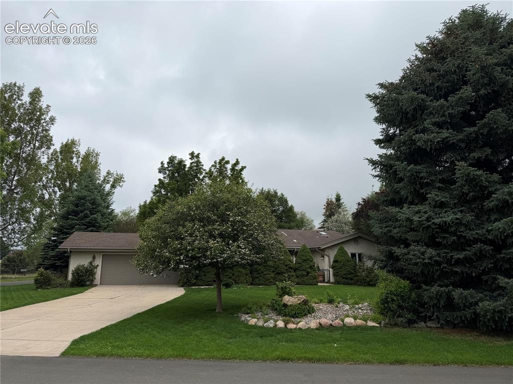 Image 1 of 21: Ranch-style exterior with a two-car garage, concrete driveway, and front la