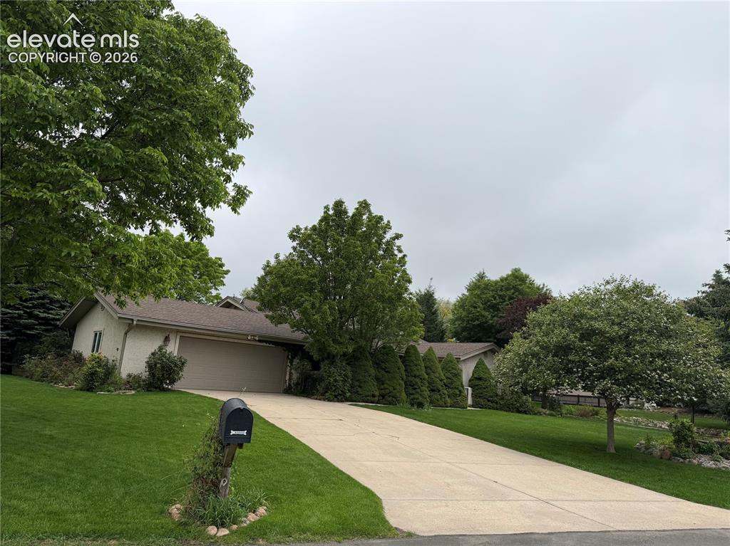 Image 2 of 21: Concrete driveway providing access to a two-car garage