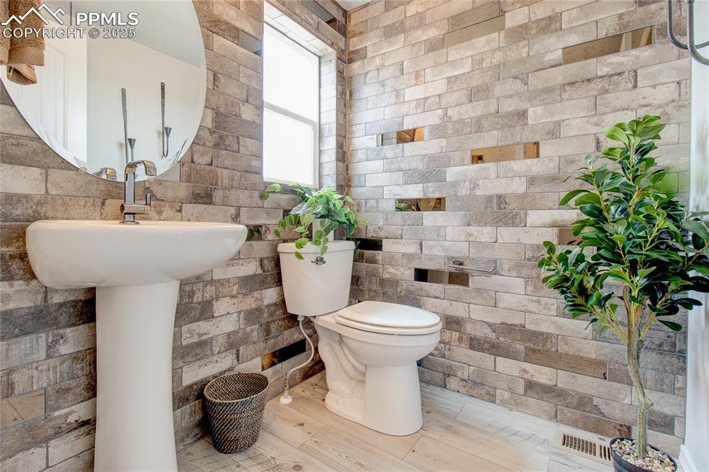 Image 10 of 25: Half bathroom featuring toilet and wood finished floors