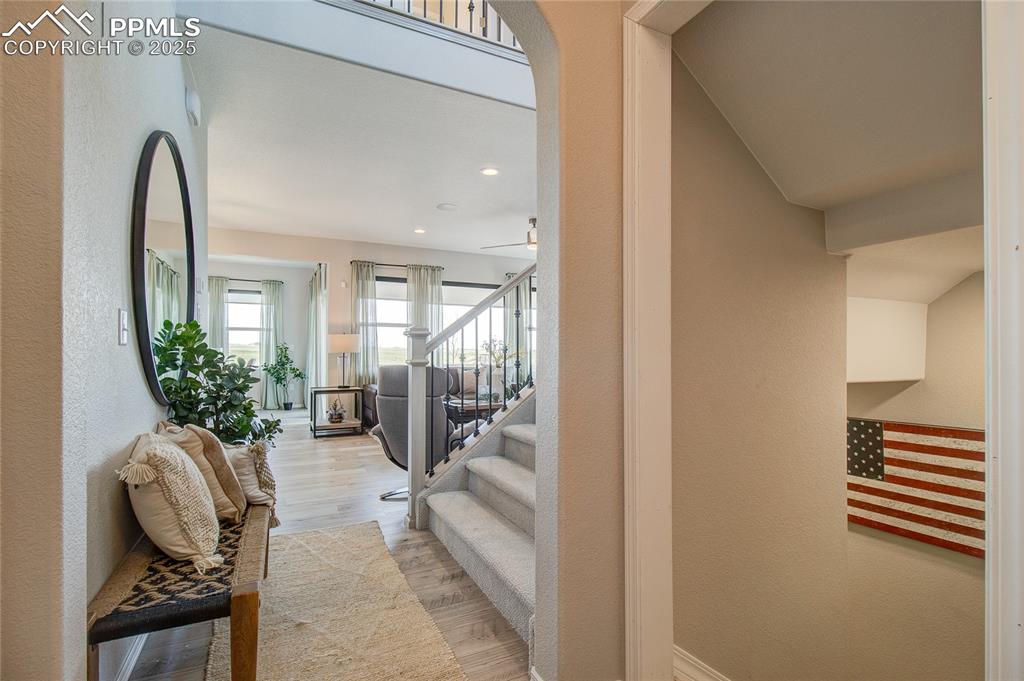 Image 2 of 25: Stairway featuring a textured wall, wood finished floors, and recessed ligh