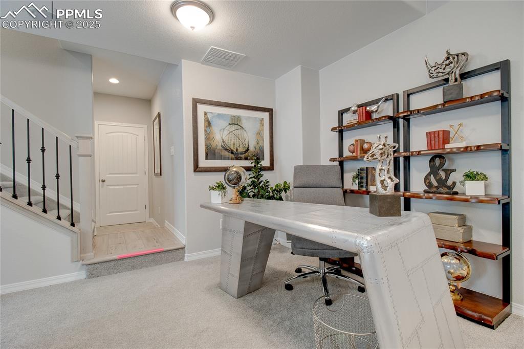Image 23 of 25: Office area with light carpet and recessed lighting