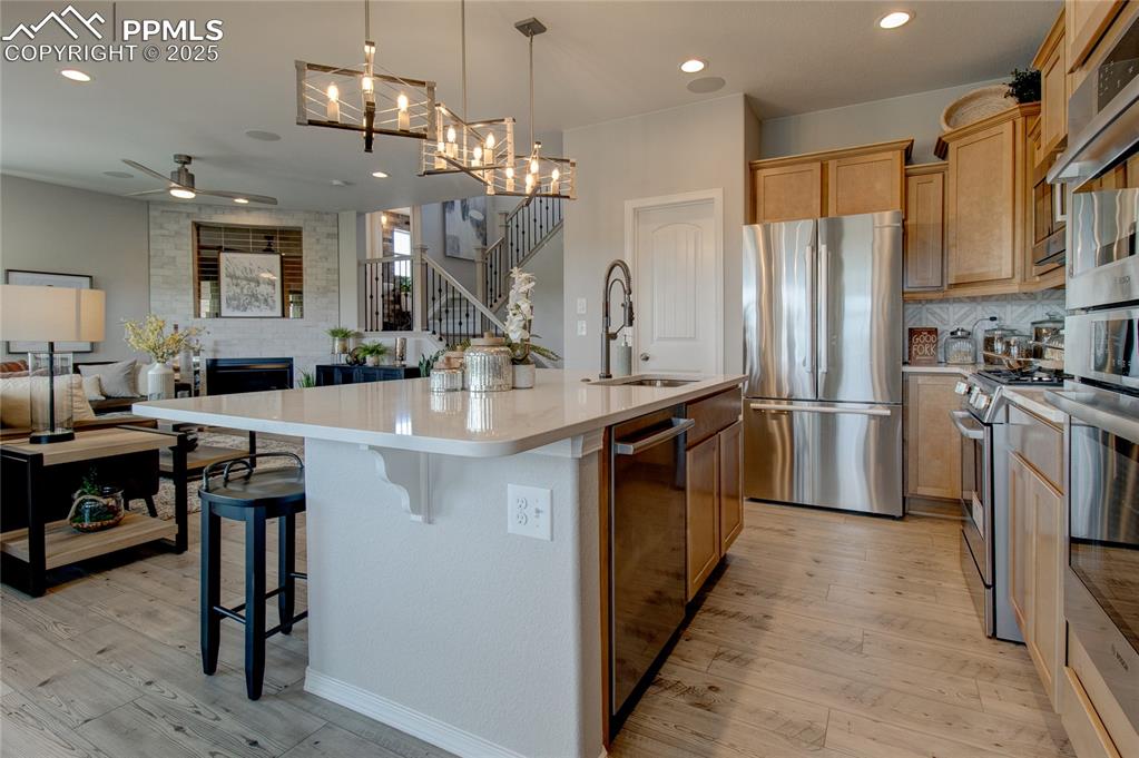 Image 8 of 25: Kitchen featuring light wood-type flooring, open floor plan, appliances wit