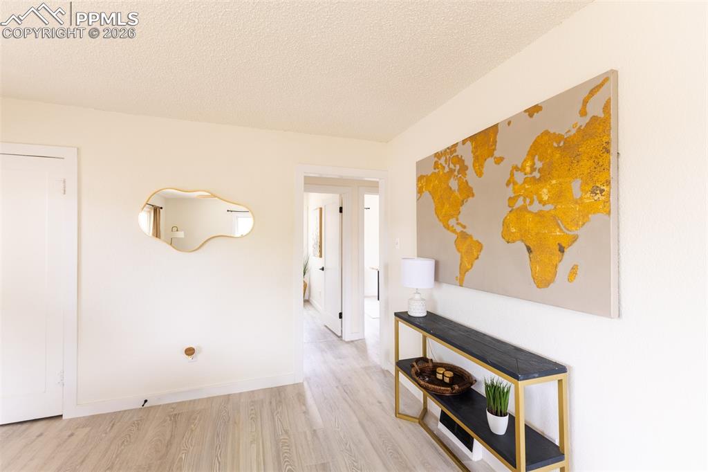 Image 12 of 24: Light wood-finish flooring extending into a doorway