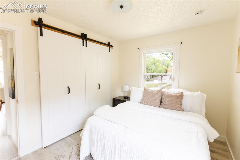 Image 15 of 24: Room featuring wood-finish flooring, a double window with white trim, and a