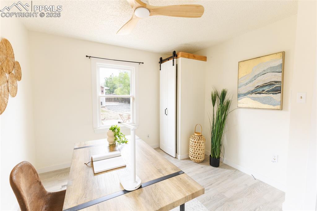 Image 16 of 24: Bright room with wood-finish flooring, a neutral color palette, a single wi