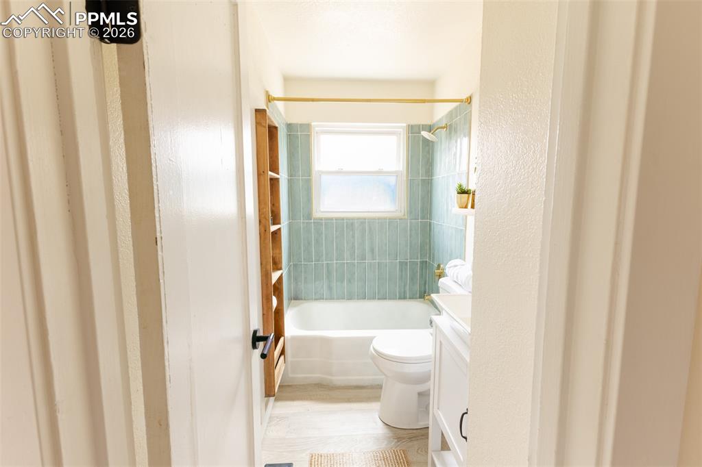 Image 18 of 24: Bathroom featuring a white bathtub, light teal subway tile surround, white 
