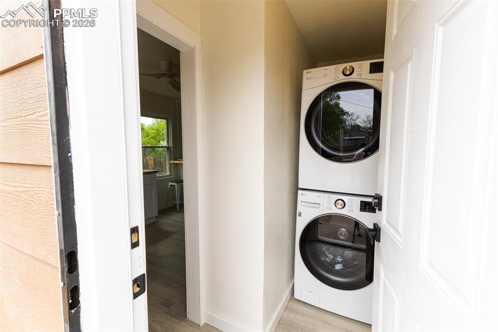 Image 24 of 24: Dedicated laundry alcove featuring a stacked washer and dryer unit, white p