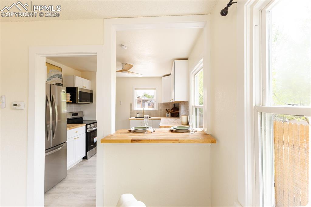 Image 7 of 24: Kitchen pass-through featuring a wood-finish countertop