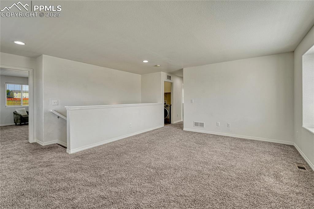 Image 25 of 50: Primary bedroom is to the left of the loft and the secondary bedrooms down