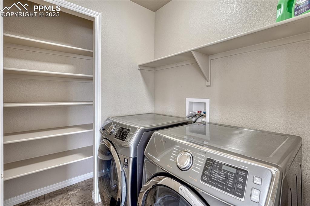 Image 32 of 50: Upper level laundry room with storage closet w/shelving