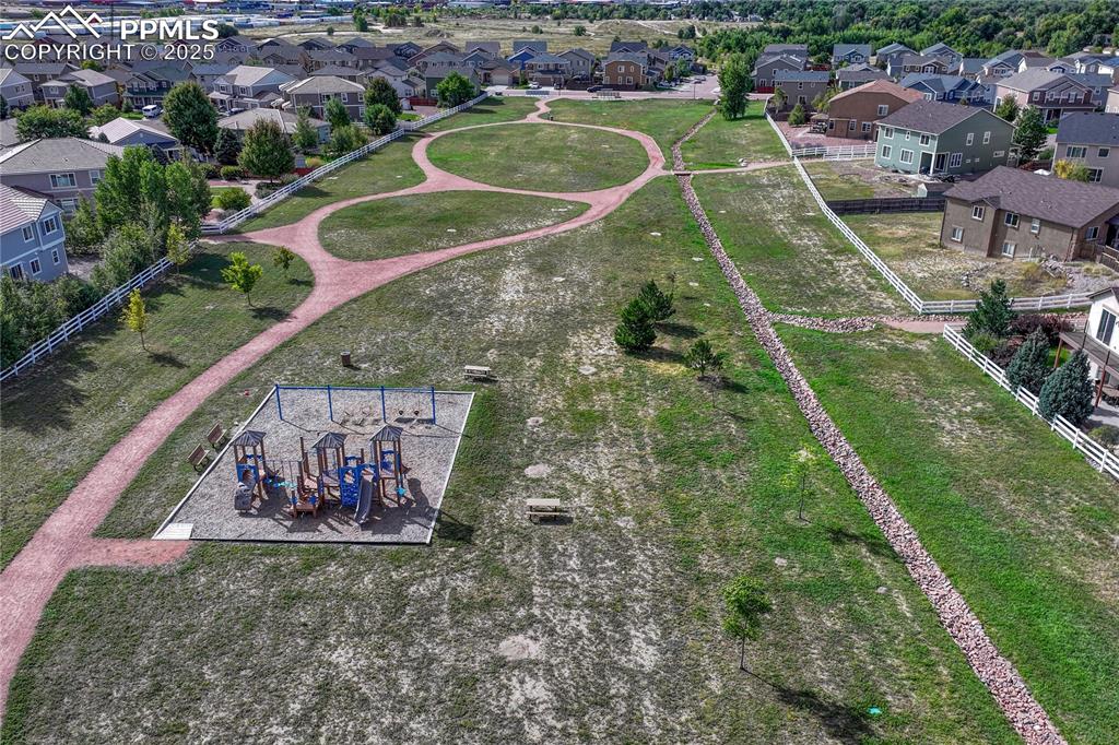 Image 48 of 50: Across the street for a park with basketball court, playground, and walking