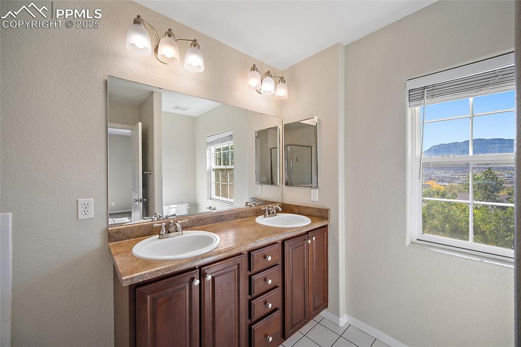 Image 28 of 50: Double sinks and plenty of storage with side mirror medicine cabinet.  