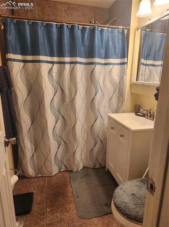 Image 8 of 10: Bathroom featuring vanity and dark tile patterned flooring