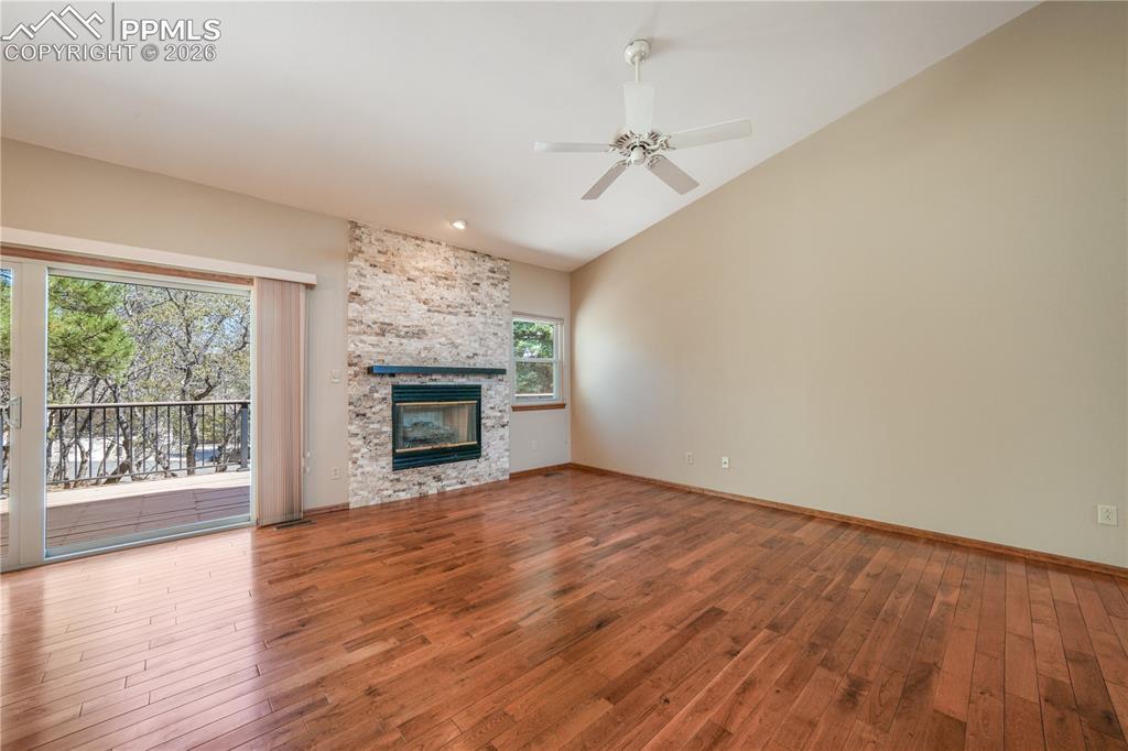 Image 10 of 50: Main living room with hardwood floors, gas fireplace, extended patio doors