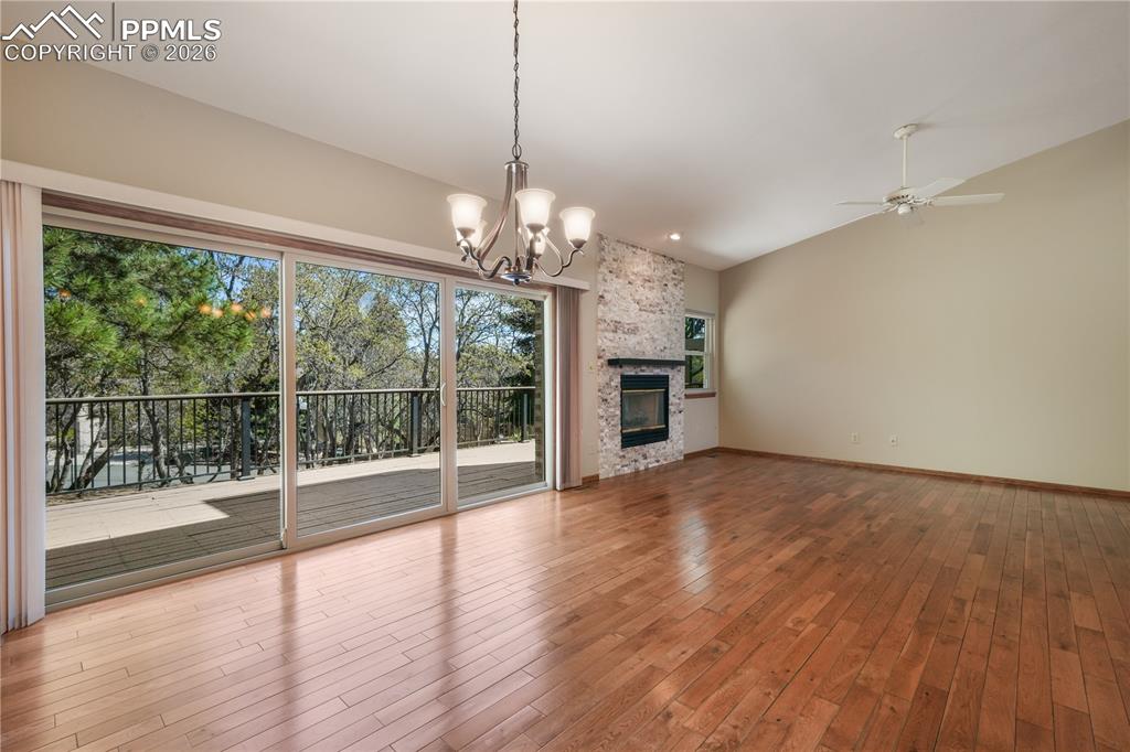 Image 11 of 50: Main living room with hardwood floors, gas fireplace, extended patio doors 